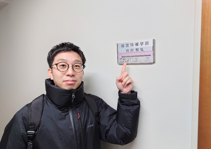 経営情報学部白川研究室前の重田優平さん